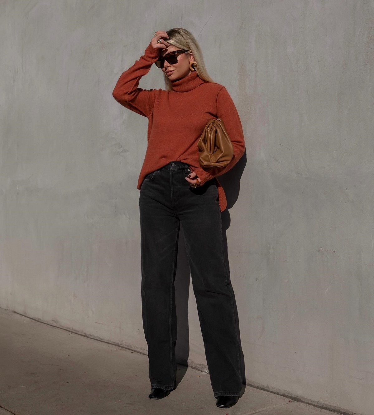 Woman in rust turtleneck sweater with black jeans