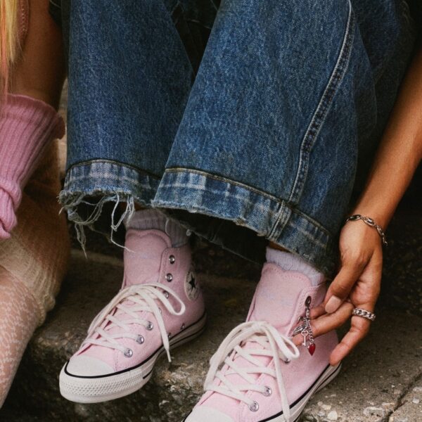 Розовые высокие кеды Converse с широкими джинсами и серыми носками