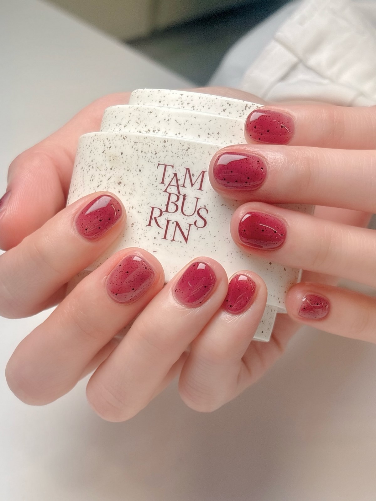 Короткий рубиновый jelly-маникюр с мелкими темными крапинками