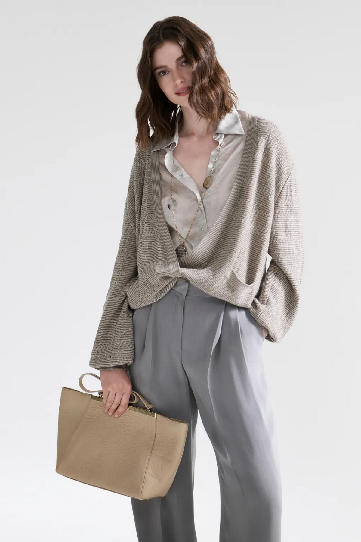 Модель в сером комплекте с объемным кардиганом и бежевой сумкой Giorgio Armani Resort 2027