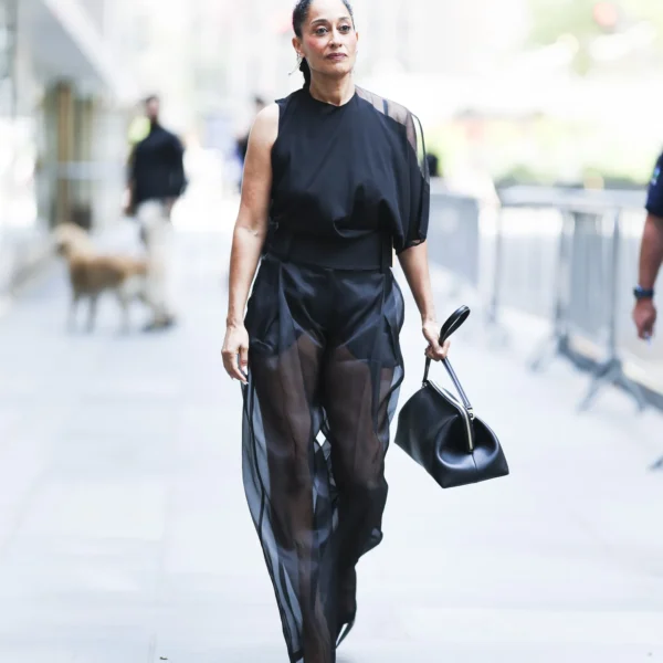 Женщина в черном топе и прозрачных широких брюках с короткой непрозрачной основой