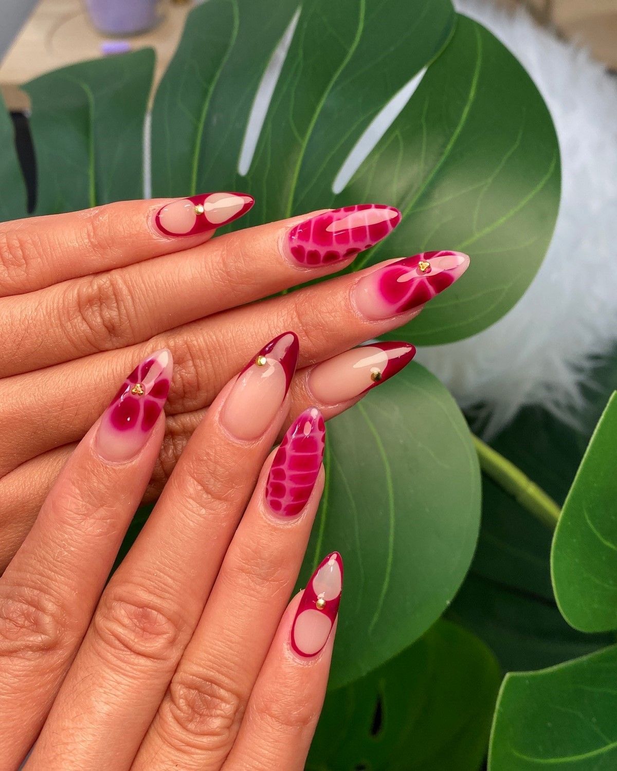 Ярко-розовый маникюр blooming gel с цветами, размытыми пятнами и золотыми деталями