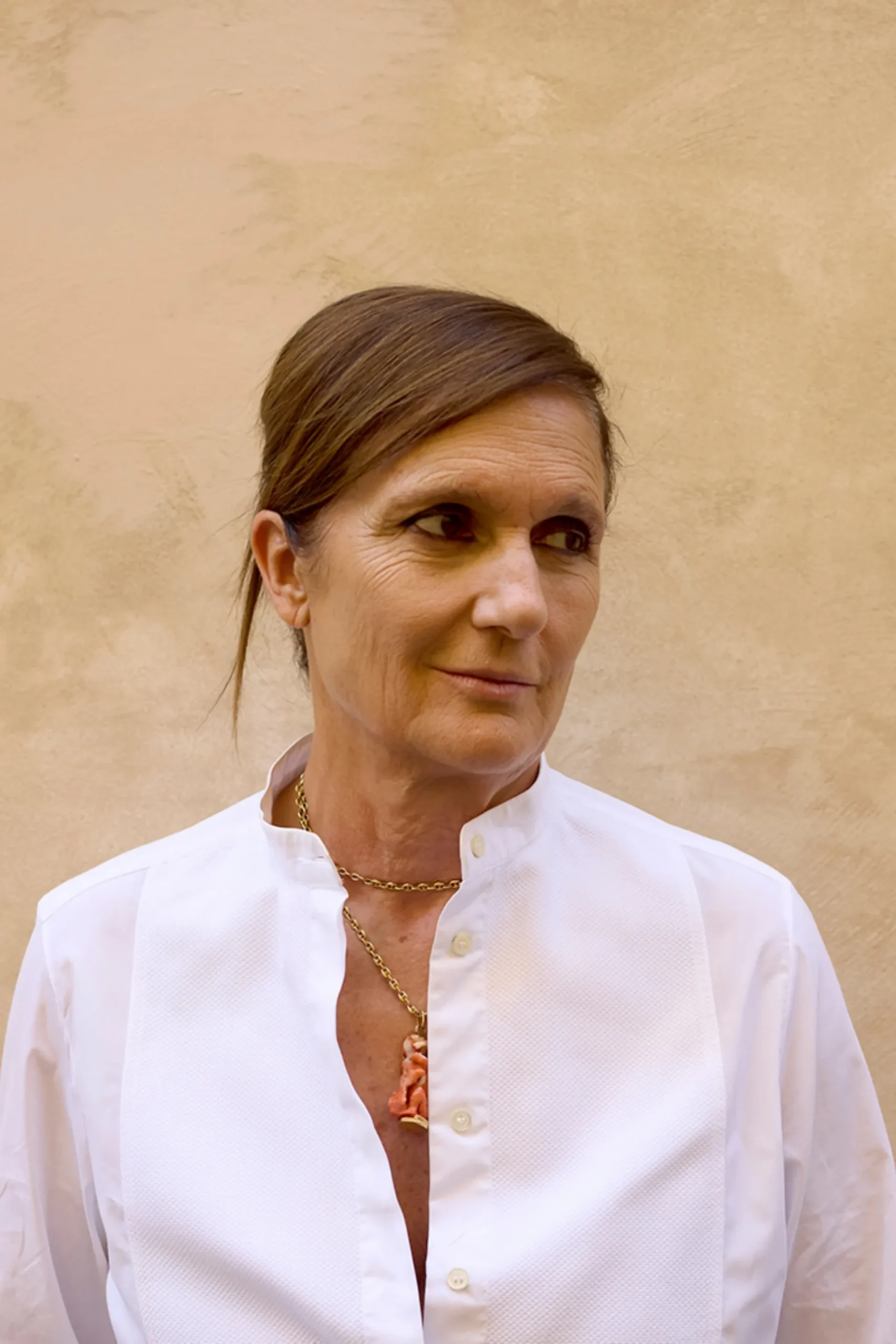 Maria Grazia Chiuri в белой рубашке на бежевом фоне