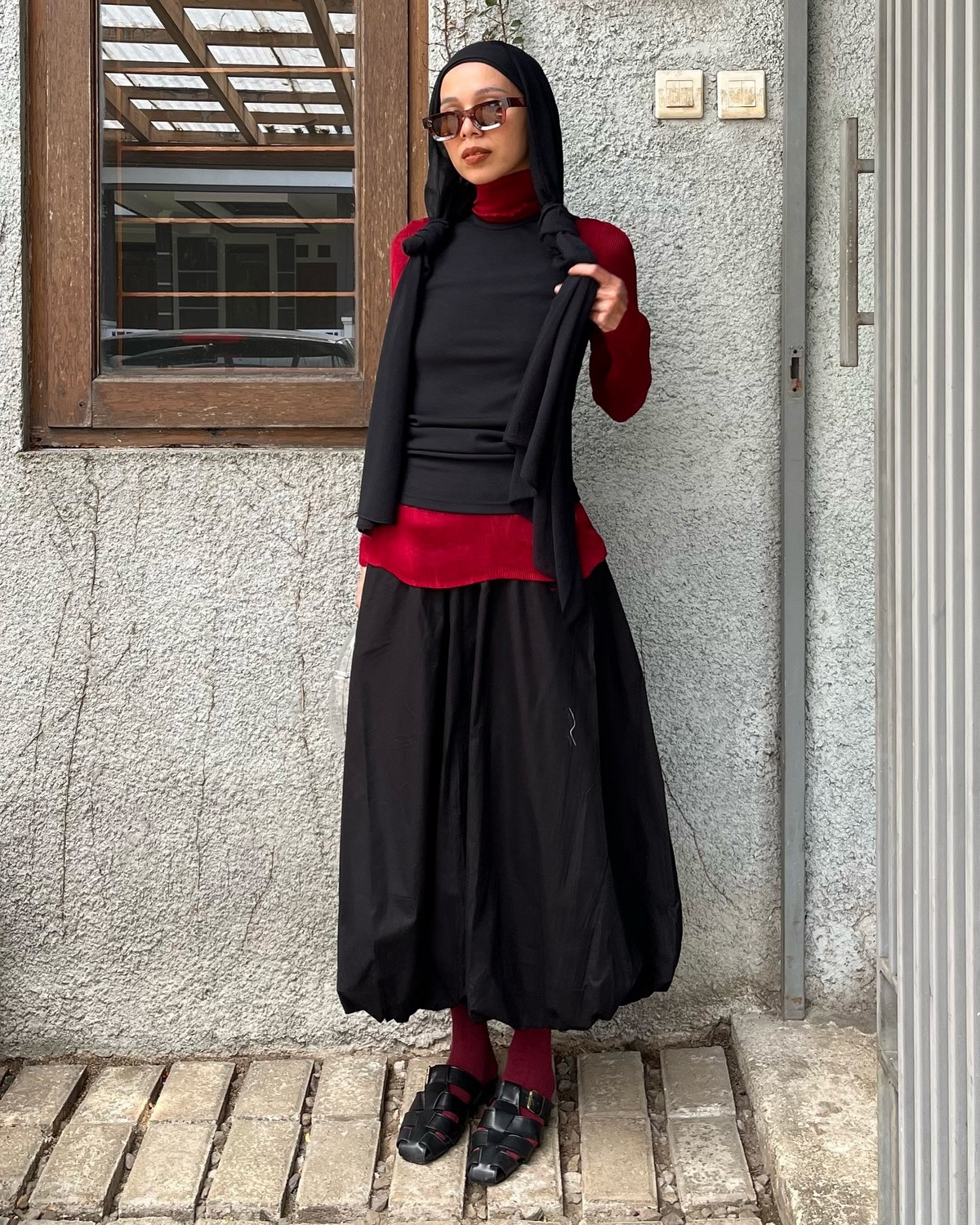 Черная balloon skirt в многослойном образе с красными акцентами