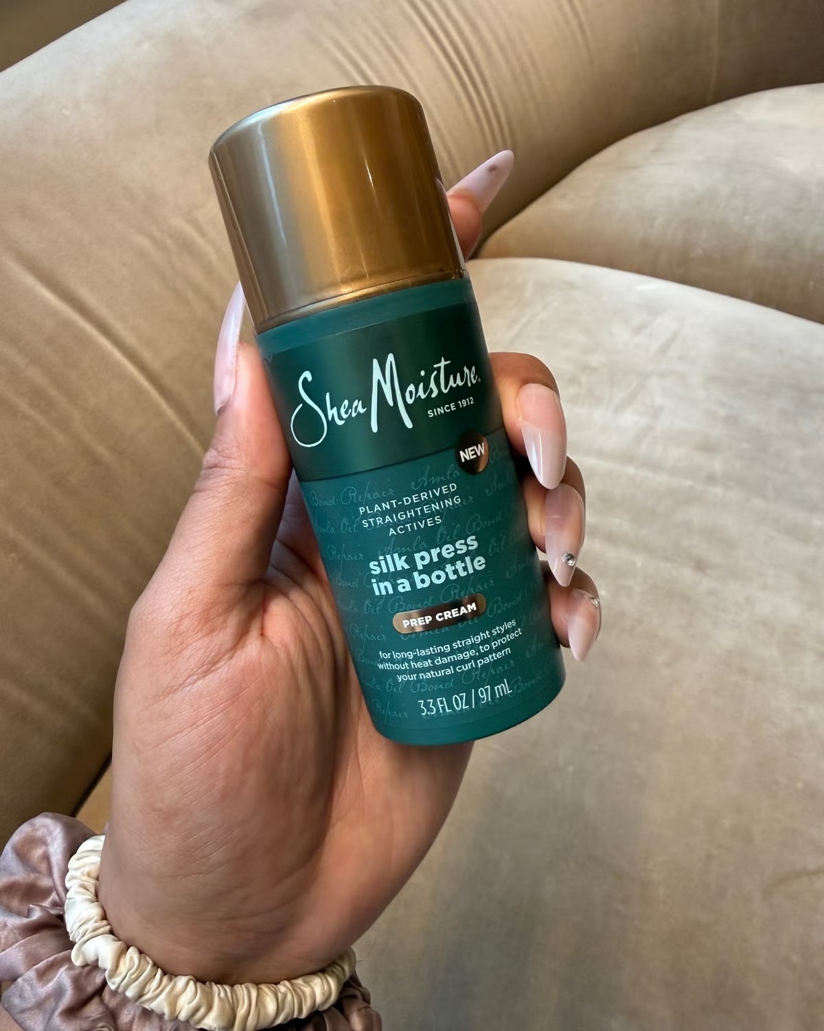 Термозащитный крем SheaMoisture Silk Press in a Bottle в руке
