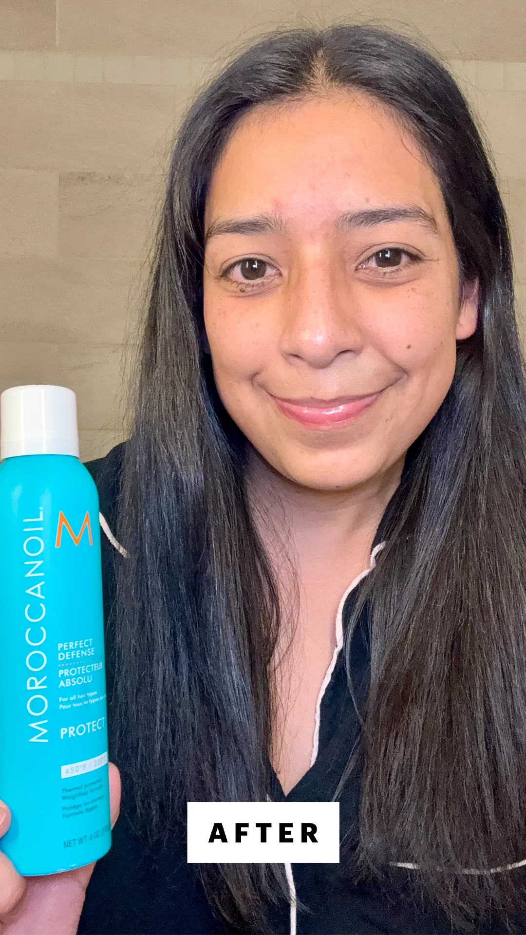 Девушка с прямыми волосами держит термозащитный спрей Moroccanoil после укладки