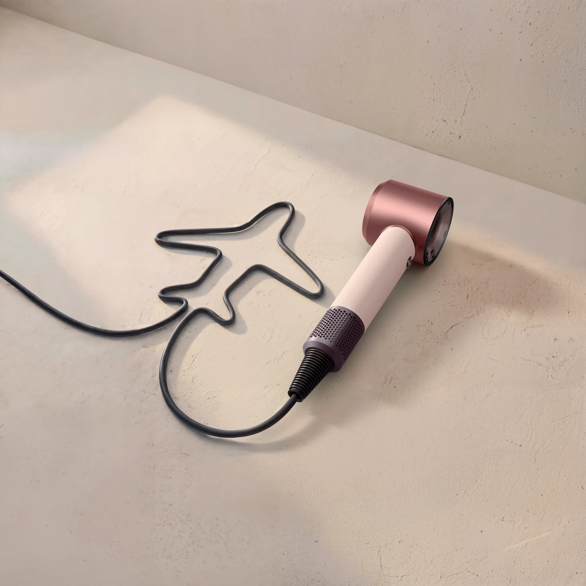 Фен Dyson Supersonic в розовом цвете на светлой поверхности