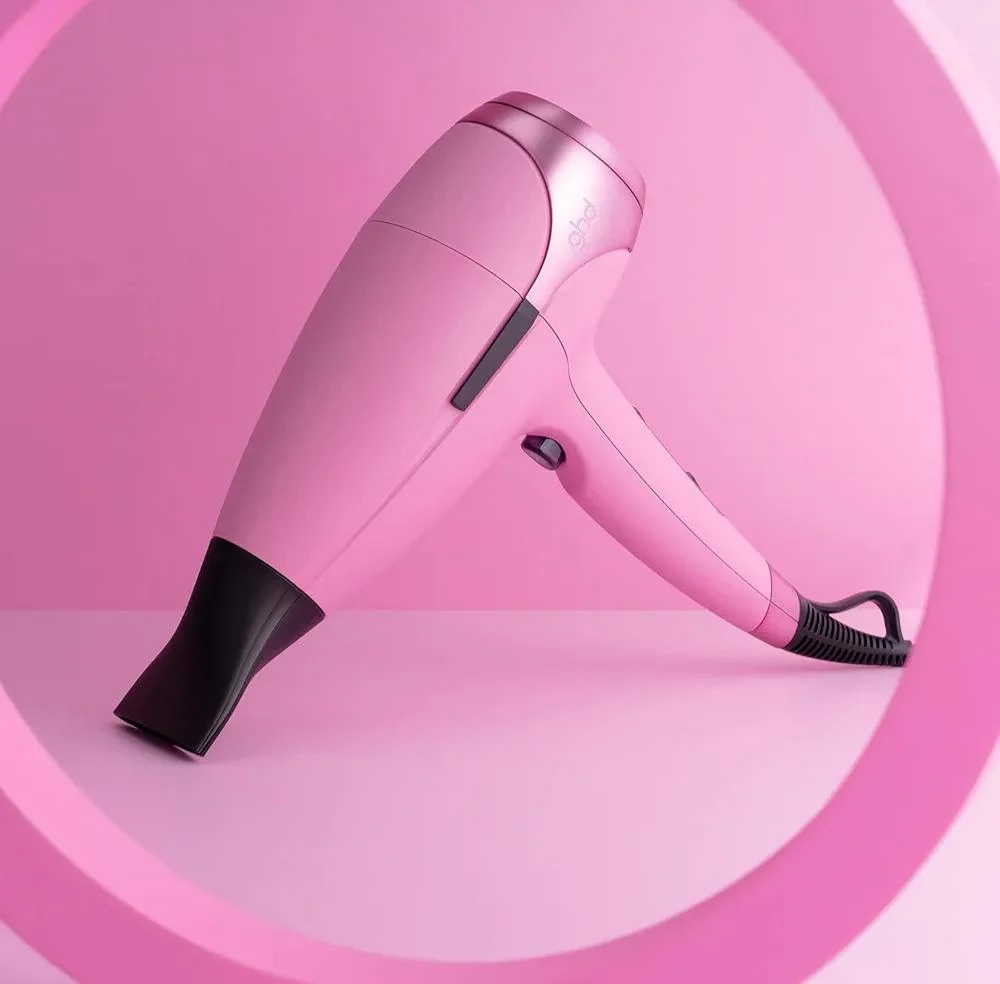 Розовый фен ghd с концентратором на ярком розовом фоне