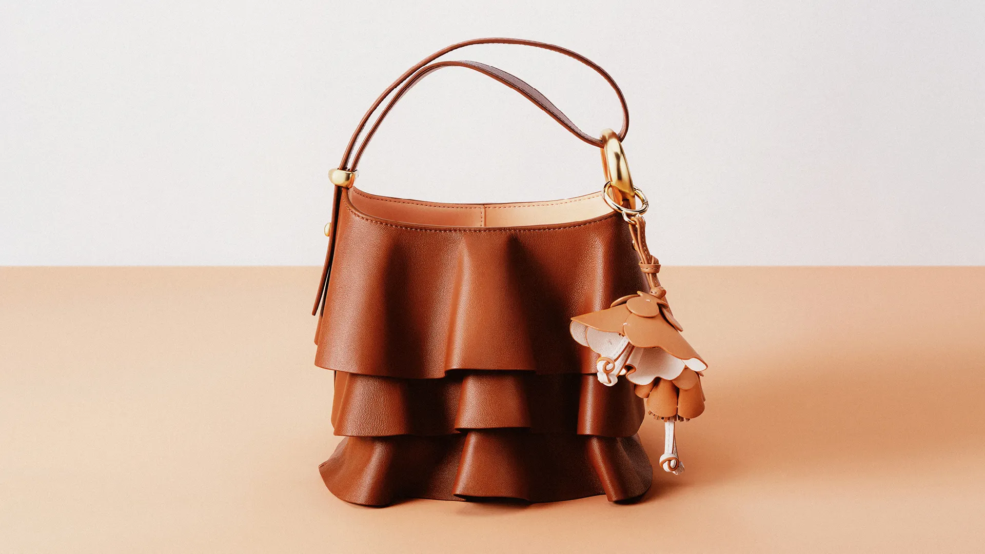 Коричневая сумка Kate Spade с кожаными оборками и подвеской в виде цветка