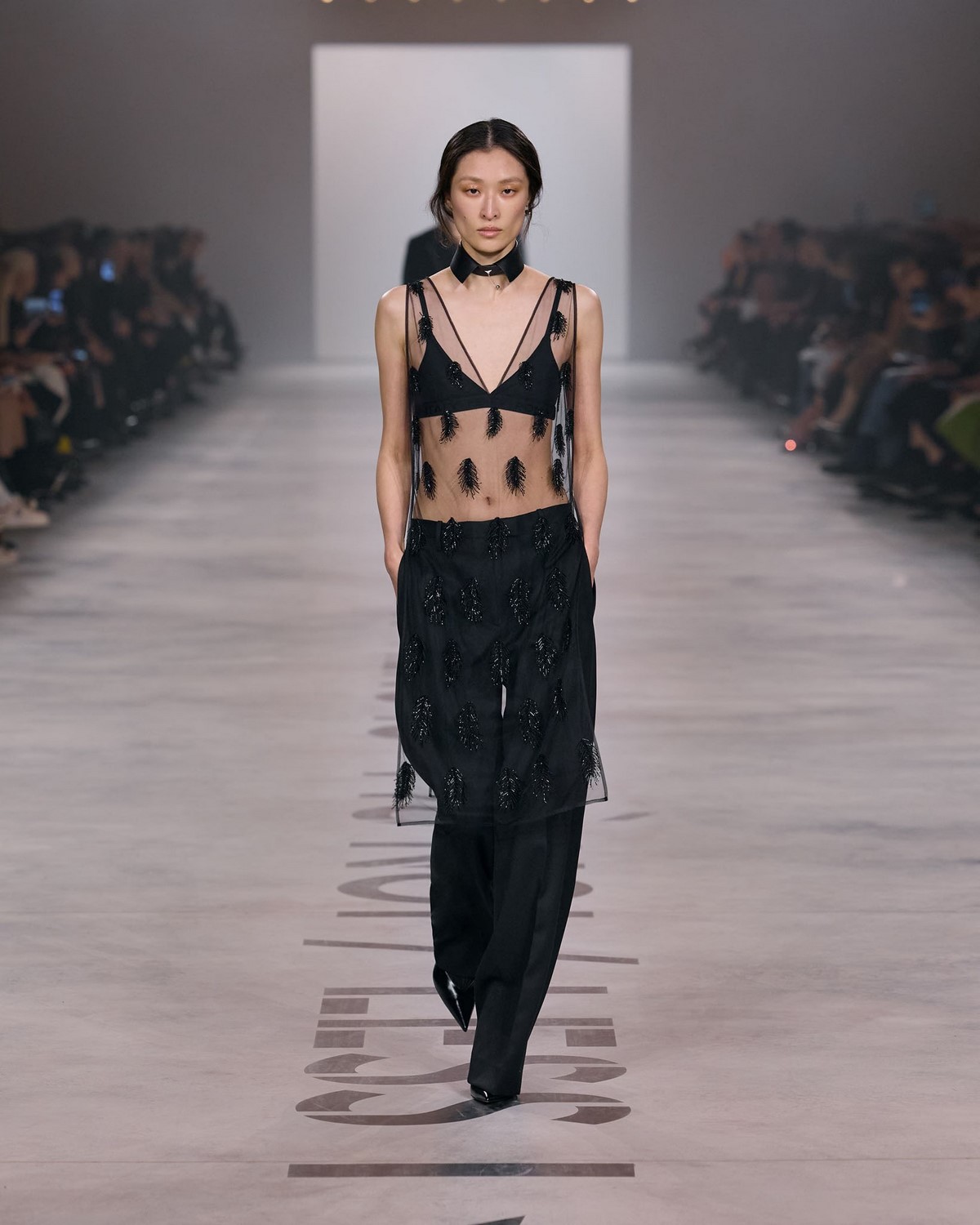 Fendi couture: прозрачный черный топ с декоративной вышивкой и широкие брюки на подиуме