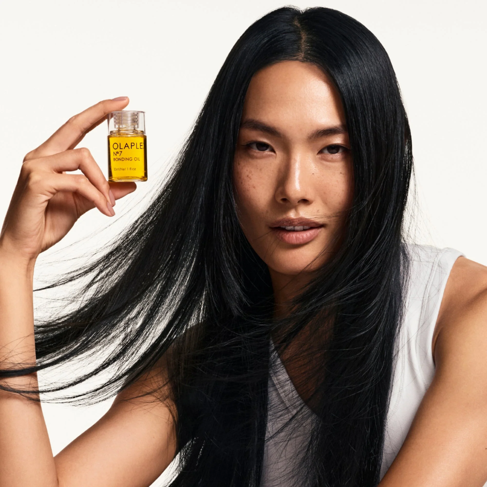 Масло для волос Olaplex Nº.7 Bonding Oil в руках у модели