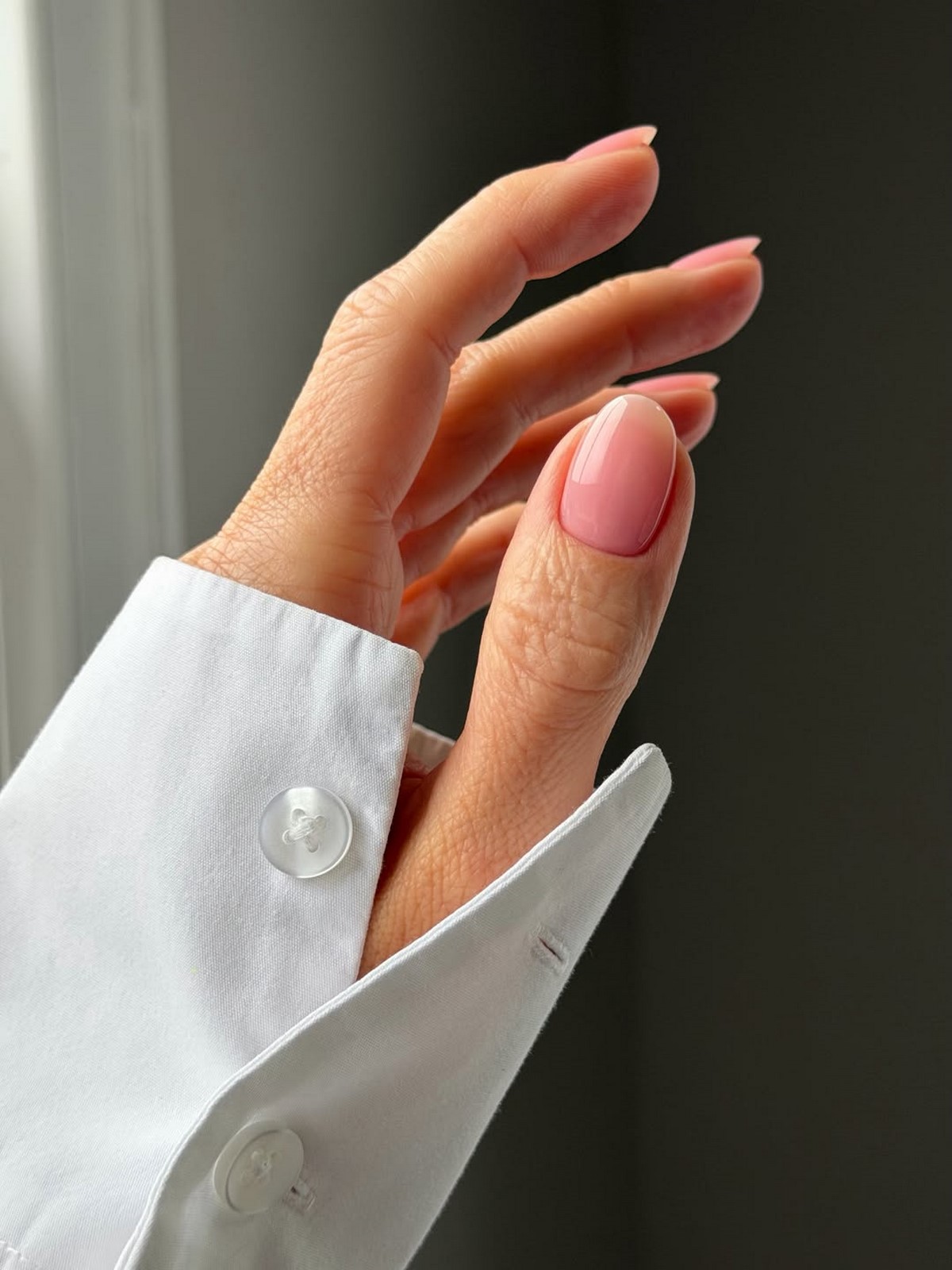 Глянцевый маникюр mochi pink на миндалевидных ногтях в естественном свете