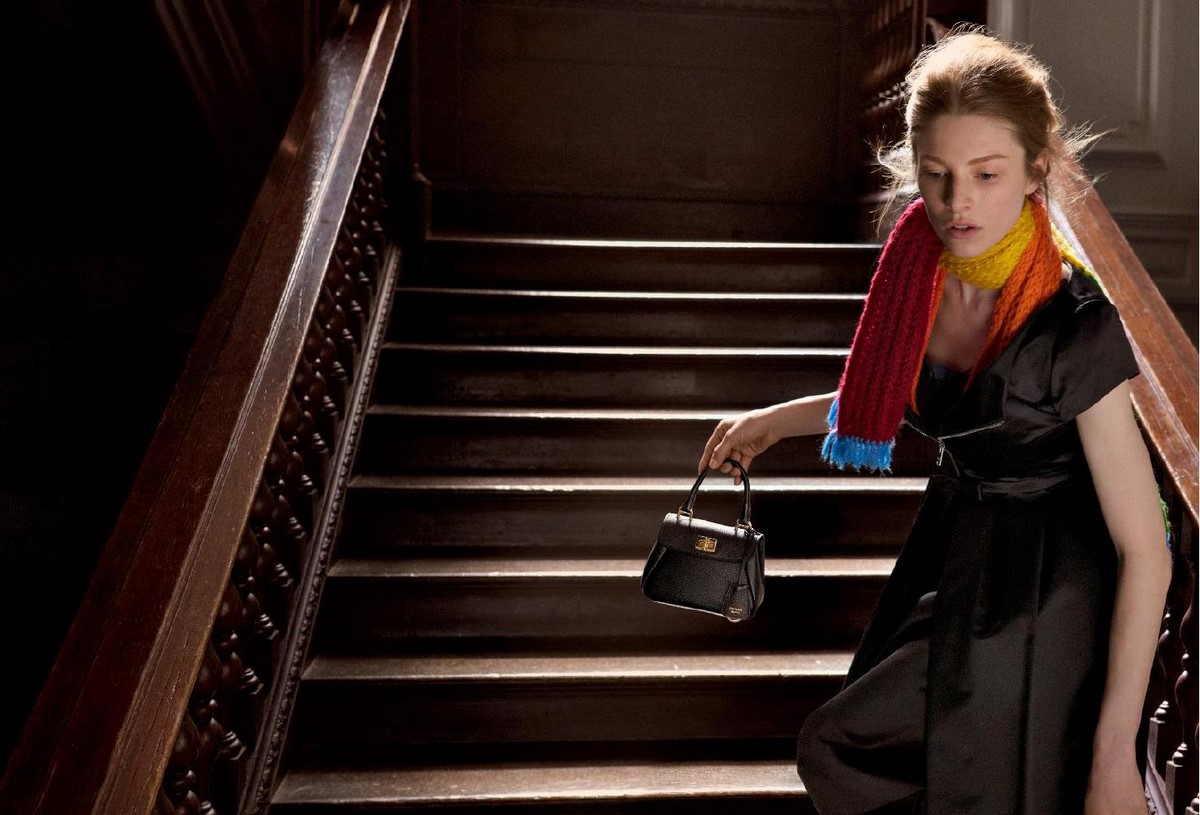 Черное платье Prada с ярким вязаным шарфом и миниатюрной сумкой