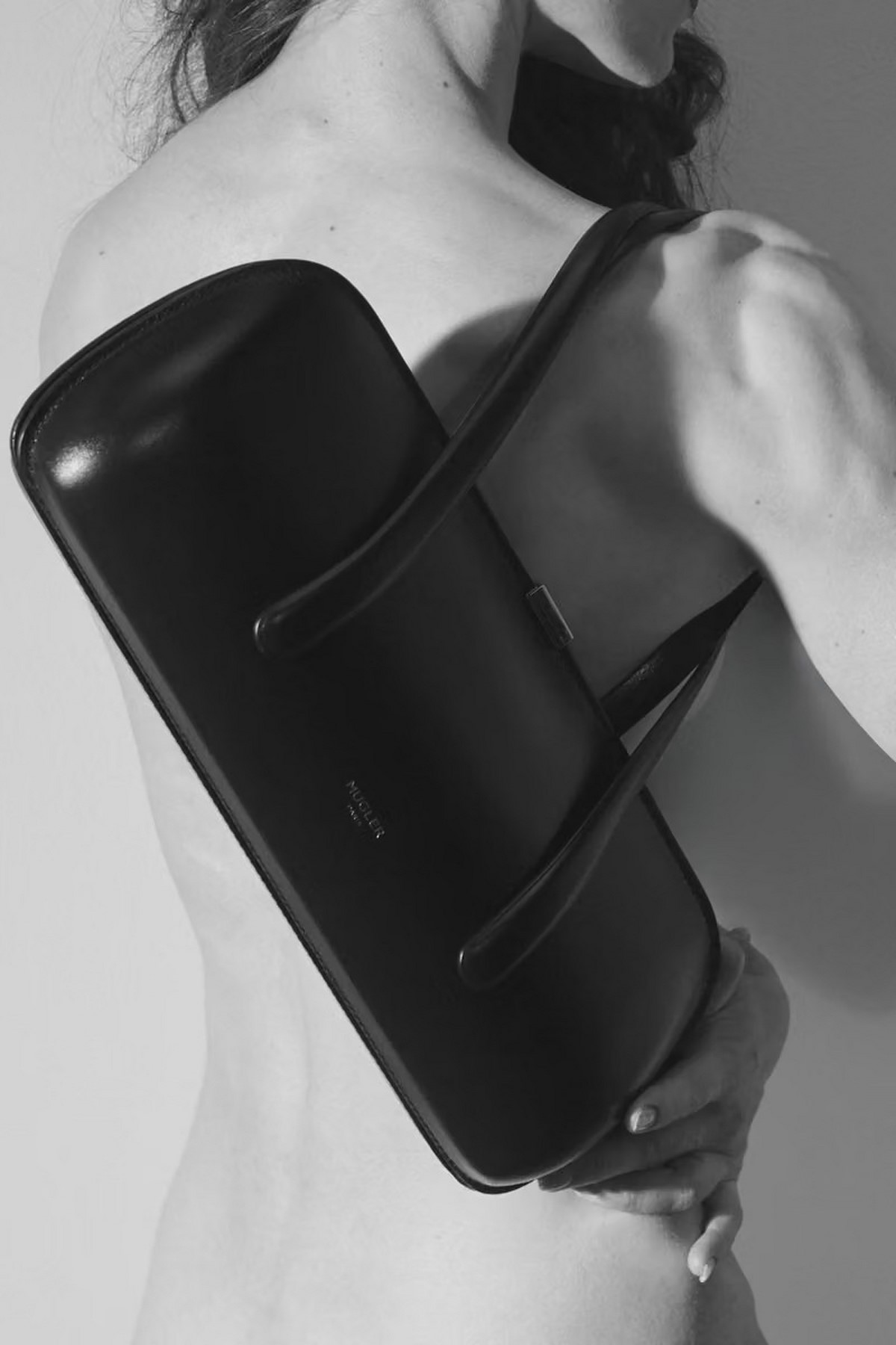 Черная сумка Mugler Aurora на плече женщины в черно-белой кампании