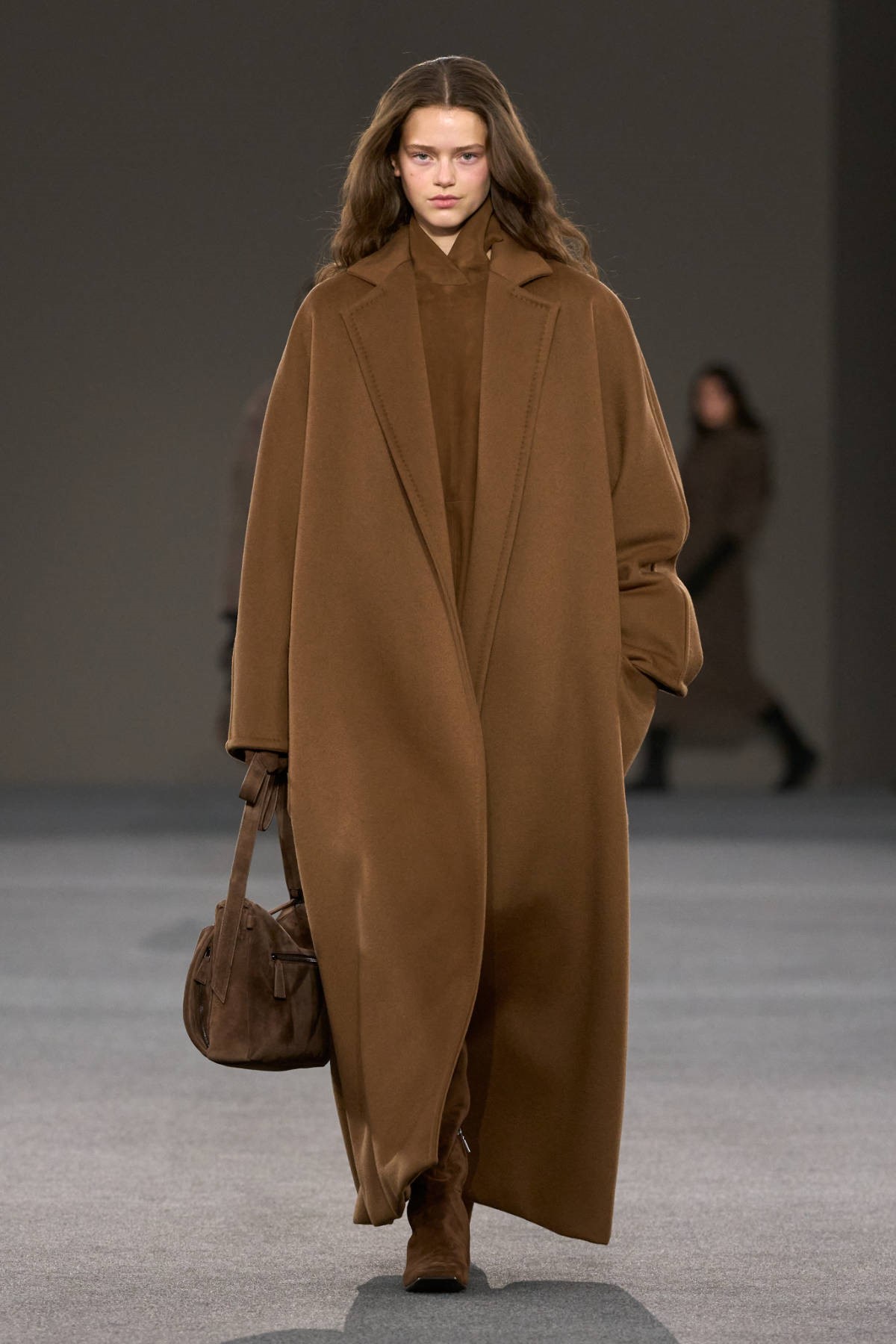 Модель в длинном коричневом пальто с округлым силуэтом на показе Max Mara