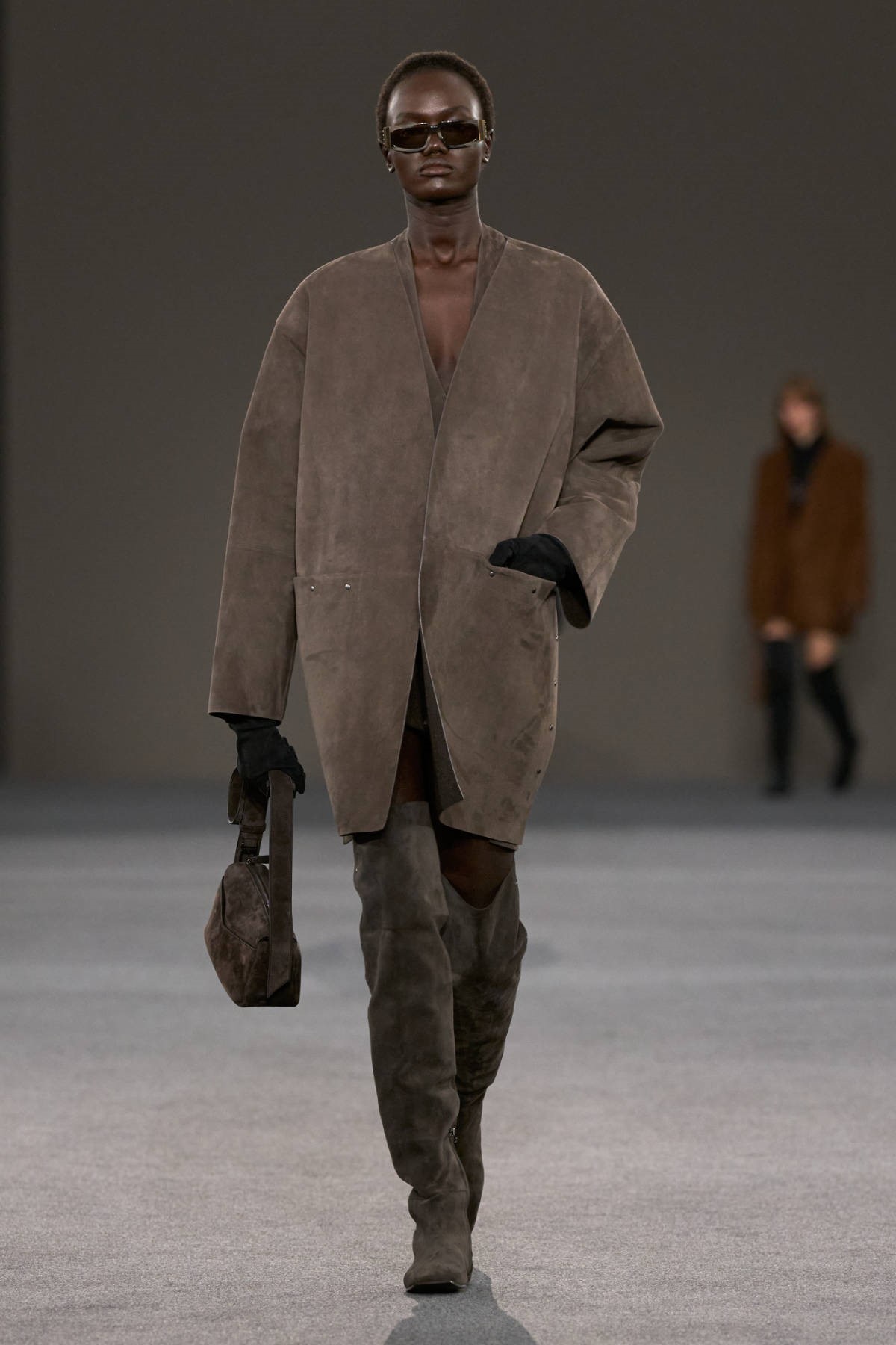Модель в свободном пальто из серо-коричневой замши на показе Max Mara